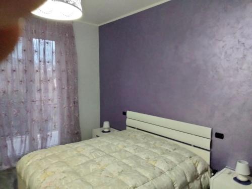 um quarto com uma cama e uma parede roxa em Le due Rive em Tufo