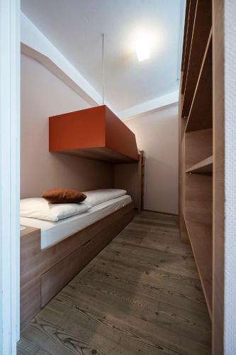 a small room with a bed and shelves at Residence Königswarte Strata Sexten in Sesto