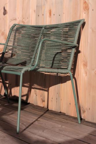a green chair sitting next to a wooden wall at Ferienturm zur ehemal. Umspannstation Poppenroth in Bad Kissingen
