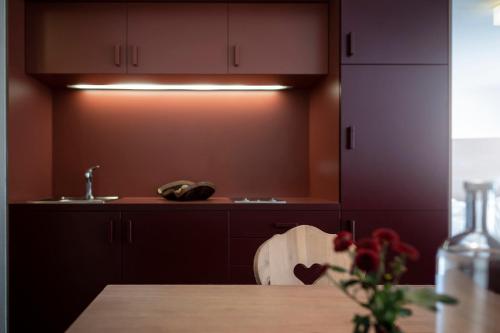 a kitchen with brown cabinets and a wooden table at Residence Königswarte Strata Sexten in Sesto