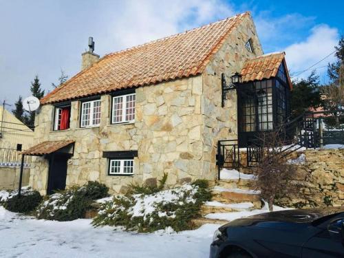 a large stone house with snow on the ground at Juniper Star House - Penhas da Saúde,Serra Estrela in Cortes do Meio
