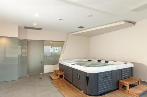 a jacuzzi tub in a room with two benches at Princess Sun Hotel in Kiotari