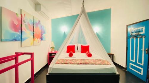 a bedroom with a canopy bed with red pillows at The Courtyard Villa in Sigiriya