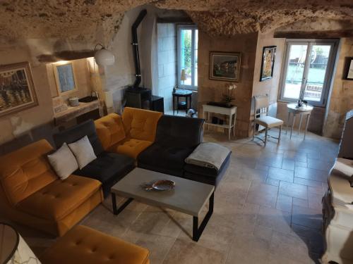a living room with a couch and a table at Les Iris - gîte insolite troglodytique in Trôo