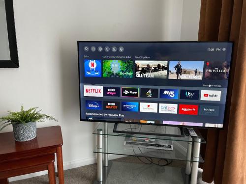 a flat screen tv sitting on top of a glass table at The Number Eleven Apartment in Kilmuir