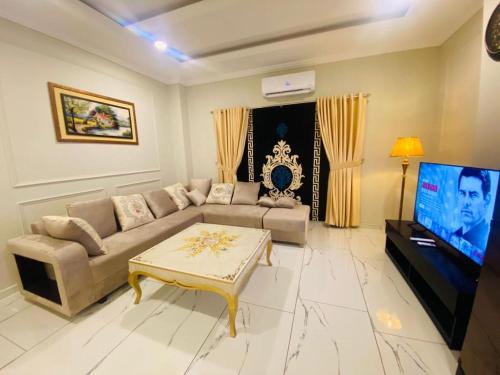 a living room with a couch and a tv at Holidazzle Serviced Apartments Bahria Town in Rawalpindi