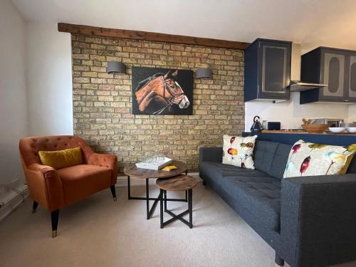 a living room with a blue couch and a horse picture on the wall at 52 Lansdown Crescent in Cheltenham