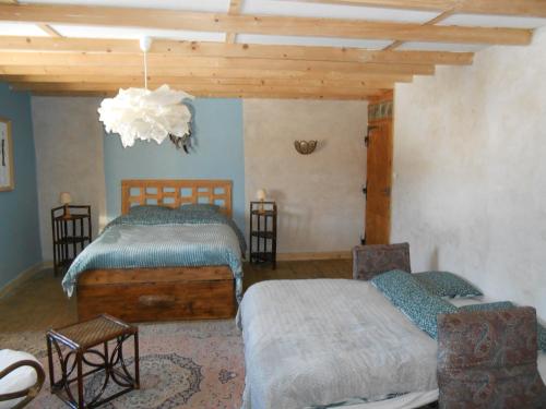 a bedroom with two beds and a chandelier at Le chalet de calisson in Châtelblanc