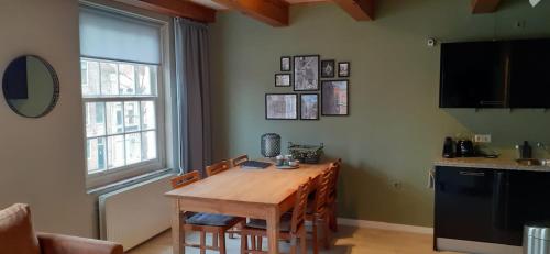 une cuisine avec une table en bois, des chaises et une fenêtre dans l'établissement Het Schaager Waapen, à Alkmaar