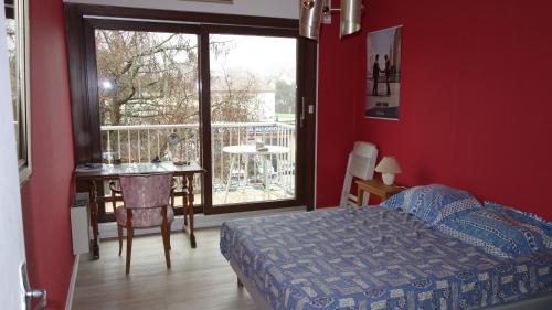 Schlafzimmer mit einem Bett und einem Tisch sowie einem Balkon in der Unterkunft Les Naïades in Gérardmer