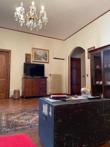 a living room with a table and a chandelier at Dimora tipica toscana in Montecatini Val di Cecina