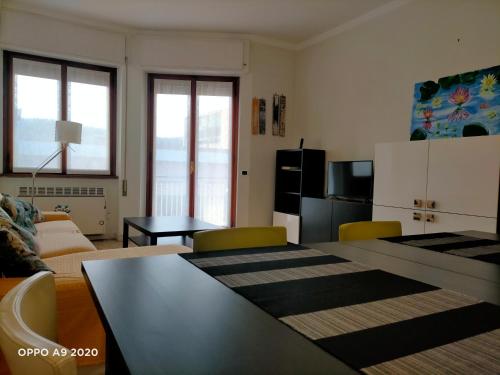 uma sala de estar com uma mesa e cadeiras e um sofá em Appartamento La Ninfea em Arona