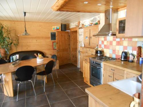 a kitchen with a table and a stove at Le chalet de calisson in Châtelblanc