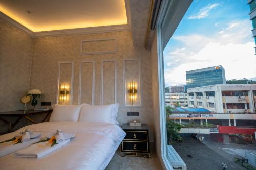 a bedroom with a large white bed and a large window at ACJ Residence @ Beside Cititel Hotel in Kota Kinabalu