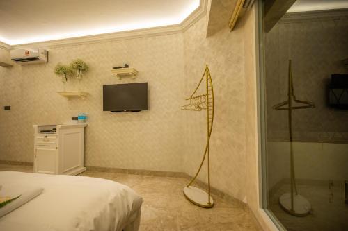 a bedroom with a shower and a television on the wall at ACJ Residence @ Beside Cititel Hotel in Kota Kinabalu