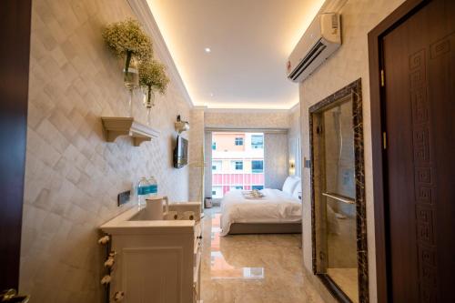 a bathroom with a sink and a bed in a room at ACJ Residence @ Beside Cititel Hotel in Kota Kinabalu