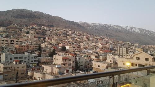 vistas a una ciudad con edificios en una montaña en Snow View Suite סוויטת סנו וויו, en Majdal Shams