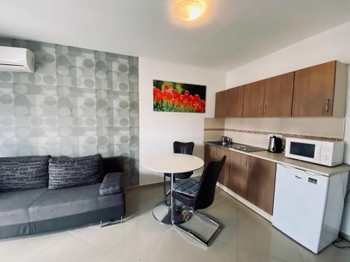 a small kitchen with a table and a couch at Byblos Wellness Apartman Siófok By BLTN in Siófok