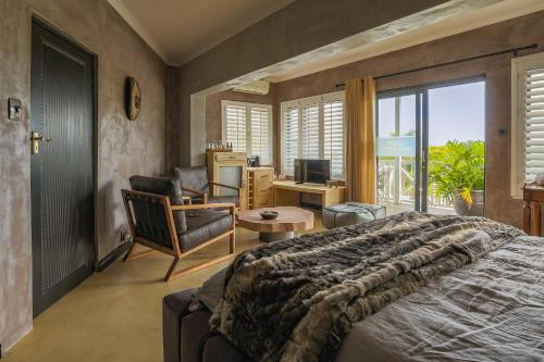 a bedroom with a bed and a desk with a computer at YEBO Boutique Guesthouse in Somerset West