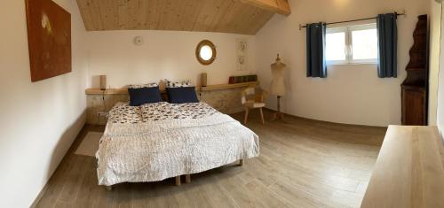 une chambre avec un lit avec des oreillers bleus et une fenêtre dans l'établissement Jardin d'Essais (Gîte), à Saint-Michel-de-Montaigne