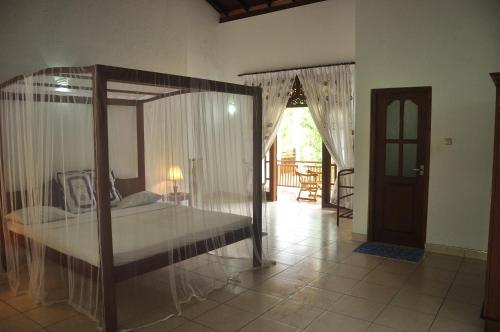 a bedroom with a canopy bed in a room at Villa Wunderschön in Bentota