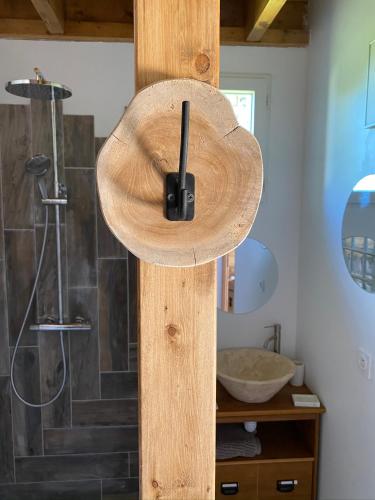 a bathroom with a shower with a wooden wall at Les Apparts in Genneville