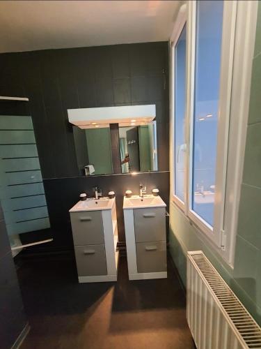 ein Badezimmer mit 2 Waschbecken und einem Spiegel in der Unterkunft New Windsor in Étretat