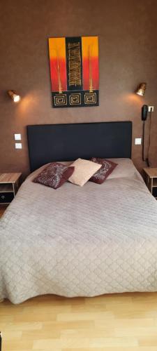 a bedroom with a large white bed with two pillows at Le Gue de Genes in Ambrieres Les Vallees