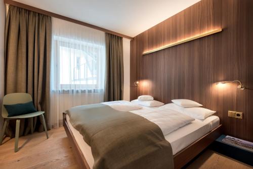 a bedroom with a large bed and a window at Residence Königswarte Strata Sexten in Sesto