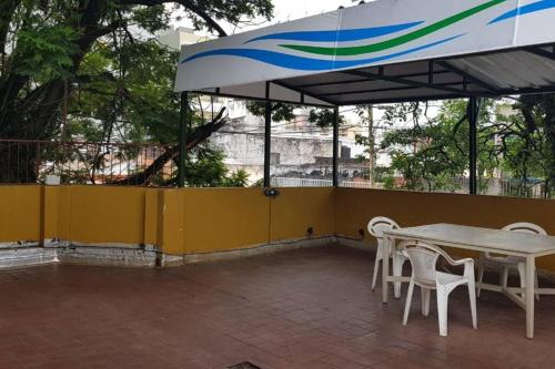 patio con tavolo e sedie sotto ombrellone di Tu Lugar en Tucumán a San Miguel de Tucumán