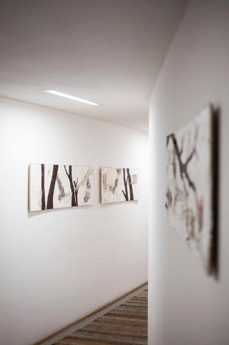 a hallway with three paintings on the wall at Residence Königswarte Strata Sexten in Sesto