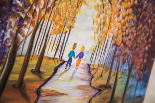 a painting of two people walking down a path at Alexandra House in Nazareth