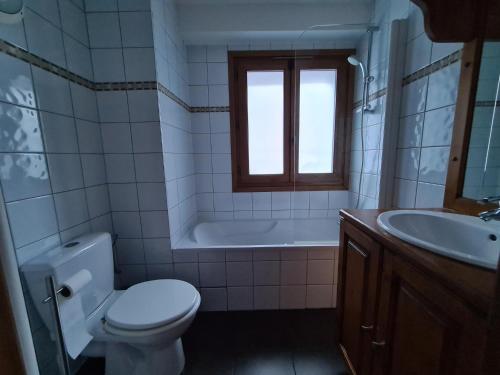 a bathroom with a toilet and a tub and a sink at Garden apartment SPA&Pool in Vallorcine