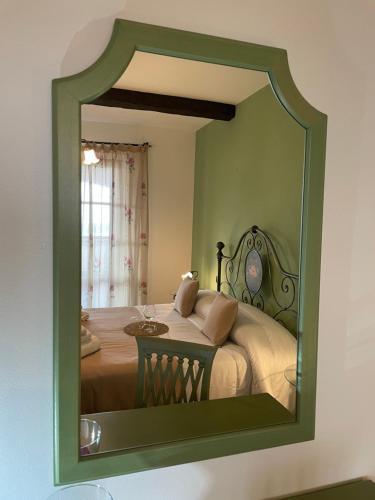 a mirror on a wall with a bed in a room at Agriturismo Il Gonzeto, Montepulciano in Montepulciano