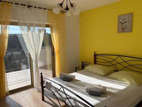 a bedroom with a bed and a large window at Apartments and Rooms Pavla in Senj