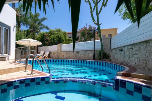 a swimming pool with blue tiles in a backyard at Villa Kallergi Nefeli 6 guests in Loutra