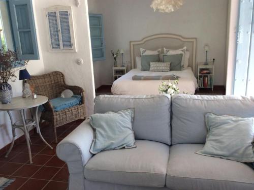 a living room with a couch and a bed at Molino Cottage in Estepona