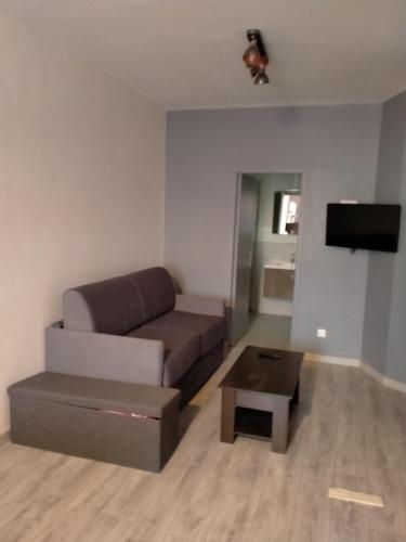 un salon avec un canapé et une table basse dans l'établissement le petit SAINT ANTOINE, à Saint-Jean-de-Maurienne