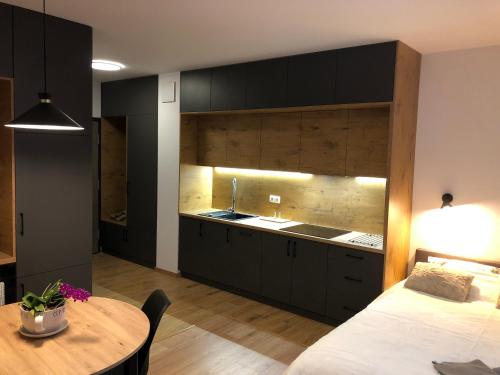a kitchen with black cabinets and a table in a room at Apartament Chopina in Łomianki