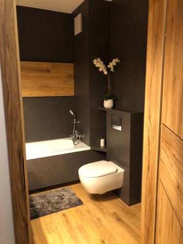 uma casa de banho com um WC branco e uma banheira em Apartament Chopina em Łomianki