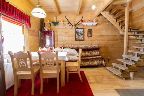 uma sala de jantar com uma mesa e cadeiras e uma escadaria em Domek Jawor em Zakopane