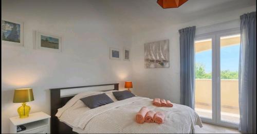 - une chambre avec un lit et des chaussons roses dans l'établissement Villa Florami, à Krnica