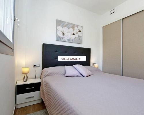 トレビエハにあるBeach Apartment Amaliaのベッドルーム1室(大型ベッド1台、ランプ2つ付)