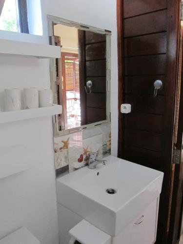 a bathroom with a white sink and a mirror at LA CASE BOIS CRÉOLE in Albion