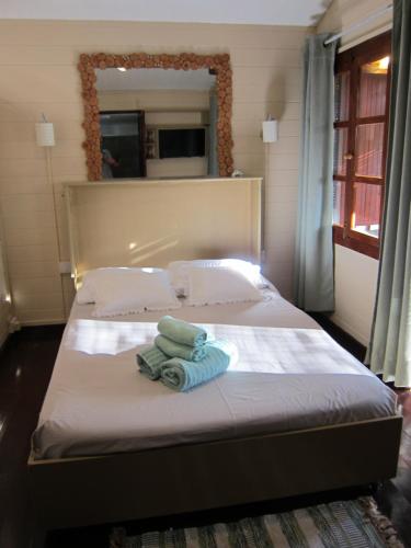 a bedroom with a bed with a towel on it at LA CASE BOIS CRÉOLE in Albion