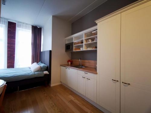 - une cuisine avec des placards blancs et un évier dans l'établissement Rotermanni Mere Apartment, à Tallinn