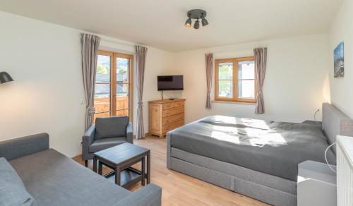 een slaapkamer met een bed, een bank en een stoel bij Rittersstuben in Garmisch-Partenkirchen