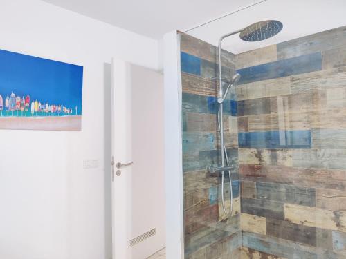 La salle de bains est pourvue d'une douche et d'un mur en bois. dans l'établissement MARAVILLA Suite 140 m2 - 3 Bedrooms, Heated Pool, à Costa del Silencio