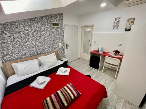 a bedroom with a red bed with a red blanket at Apartments Aleksandra in Kragujevac