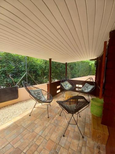 three chairs sitting on a patio under a tent at LA CASE BOIS CRÉOLE in Albion